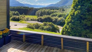 A wooden deck with a view of a forested valley and mountains. - Amazing apartment in Kvisvik (Kvisvik)