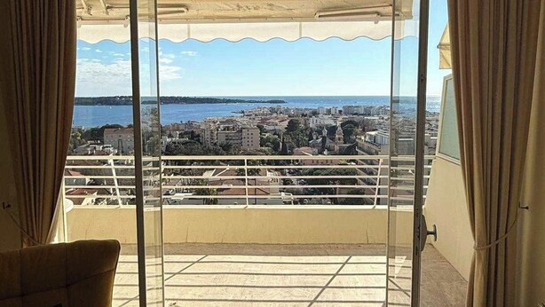 Een balkon met een helder uitzicht op een stadsgezicht en water.