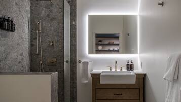 A modern bathroom with a shower, a vanity with a mirror, and a towel rack.