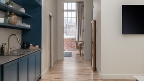 Una cocina moderna con armarios azul oscuro, encimera negra y una ventana con cortinas.
