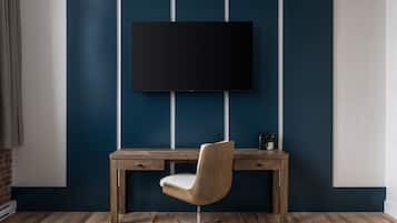Una habitació moderna amb un escriptori de fusta, una cadira i un televisor penjat.