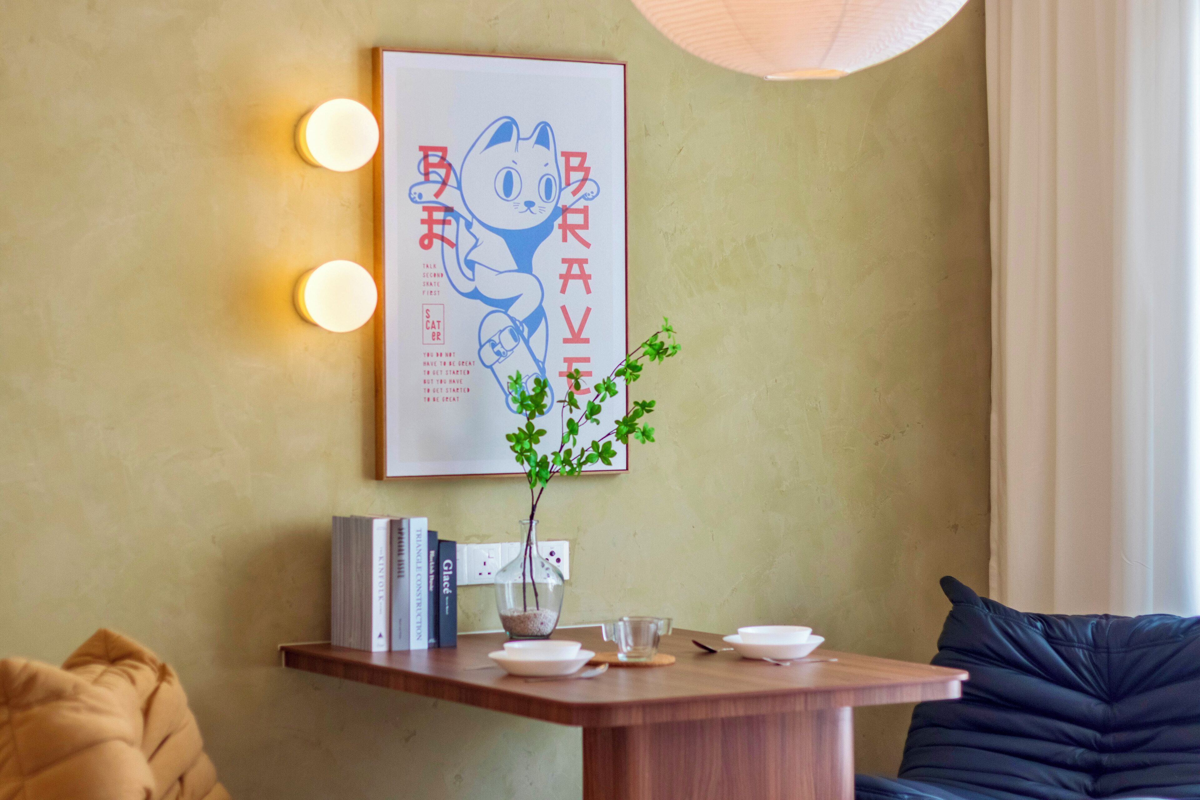 Une pièce avec une table en bois, une plante en pot et un tableau encadré accroché au mur.