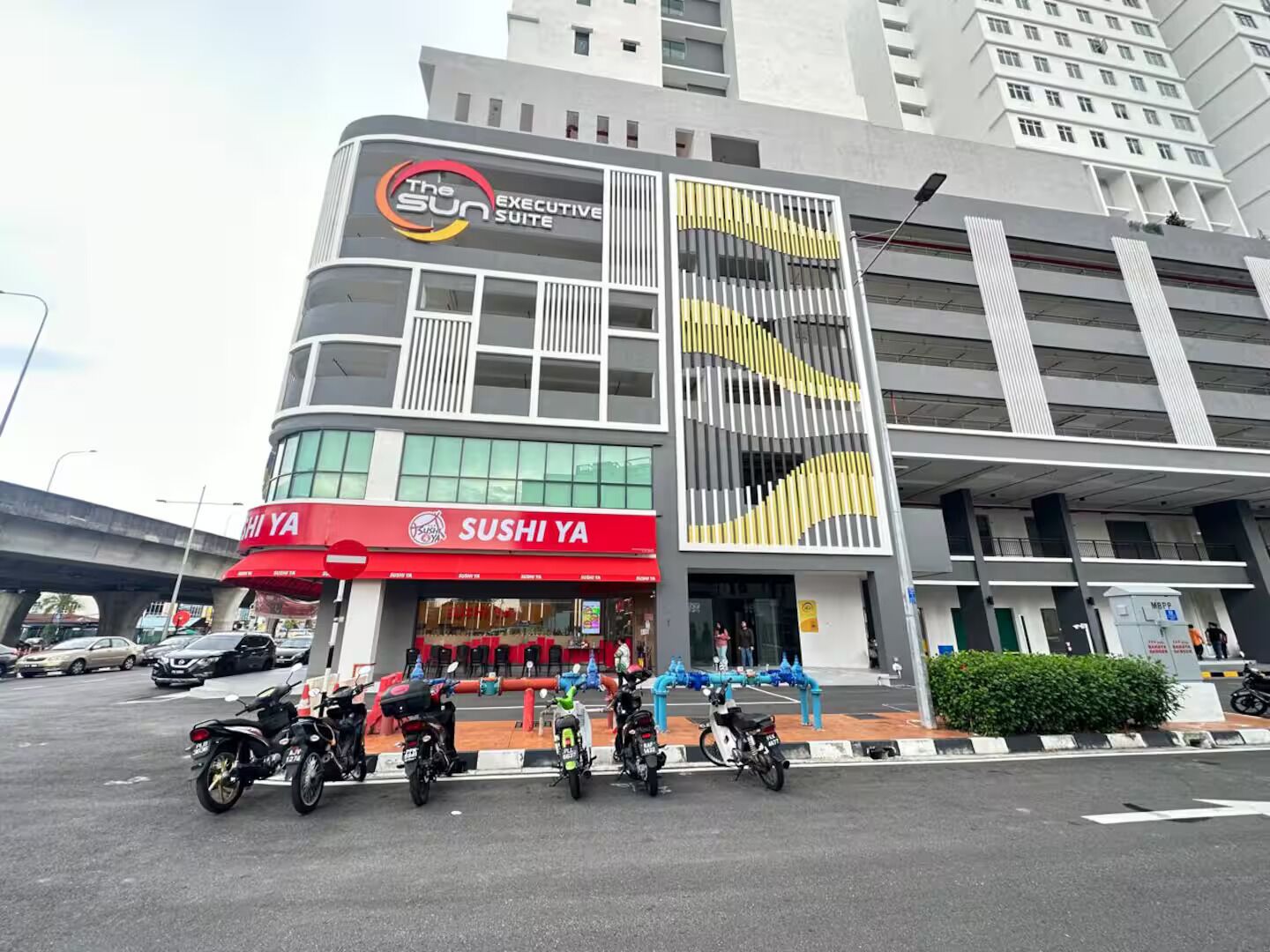 A modern building with a sushi restaurant on the ground floor.