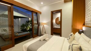 Ein Hotelzimmer mit Bett, einer Sitzecke mit Blick sowie einem Spiegel und einer Lampe.