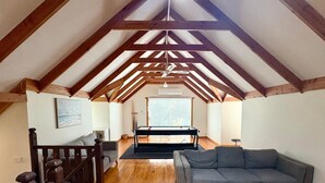 A spacious loft with high ceilings, exposed wooden beams, a piano, a sofa, and a staircase. - Timber Tides Retreat (Geographe)