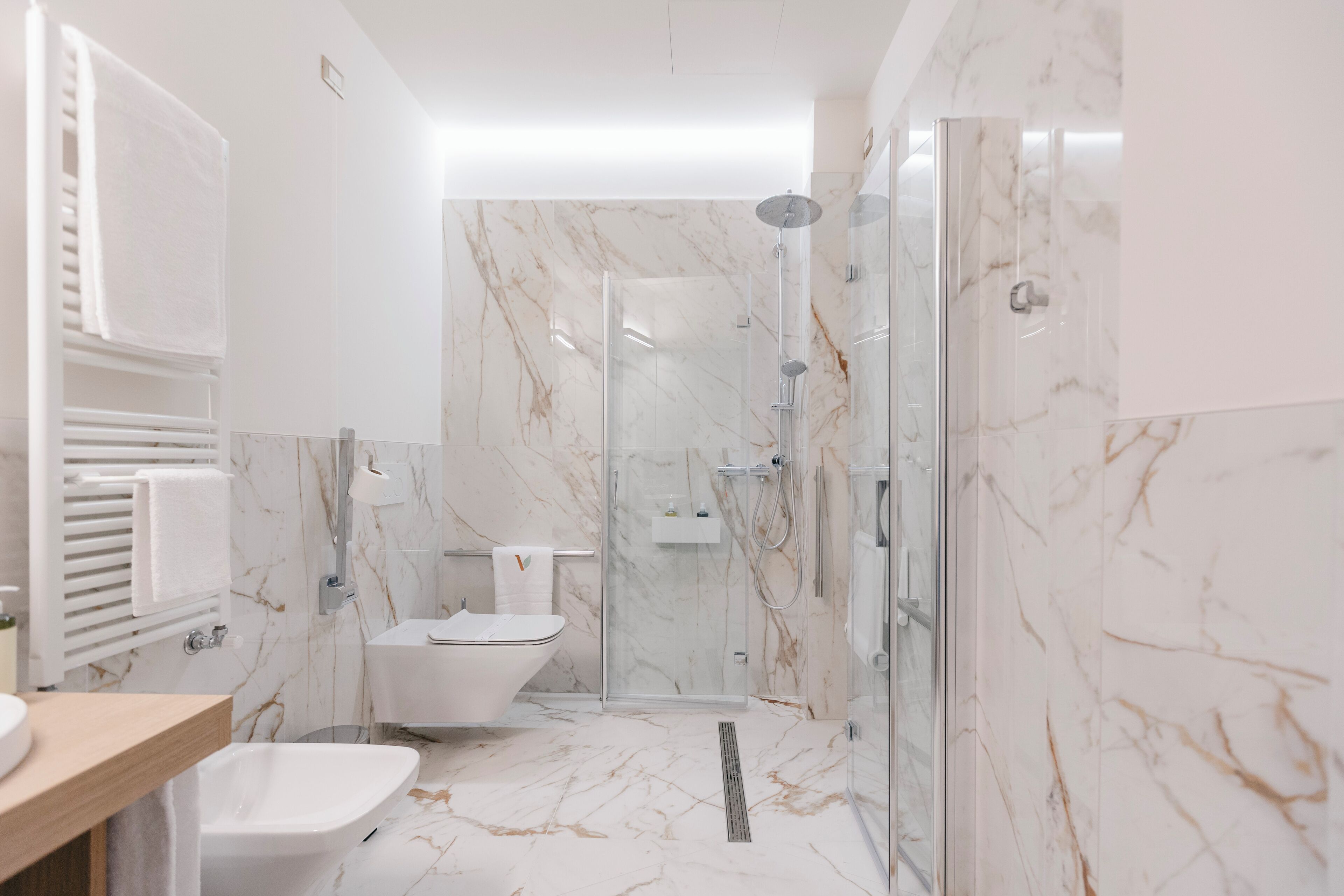 A modern bathroom with a glass-enclosed shower, a freestanding bathtub, and a toilet.