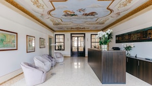 A lobby with a reception desk, seating area, and a decorative ceiling. - Villa Turco Berti Luxury Apartments&SPA (Caldiero)