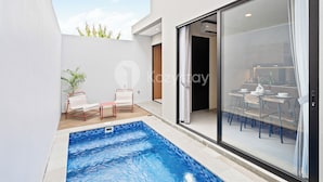 A modern outdoor pool area with a glass door leading to a dining area. - Pelora Villa by Kozystay - Jimbaran (Jimbaran)