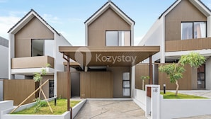 A modern building with a flat roof, a covered entrance, and a sign reading "Kozystay". - Pelora Villa by Kozystay - Jimbaran (Jimbaran)