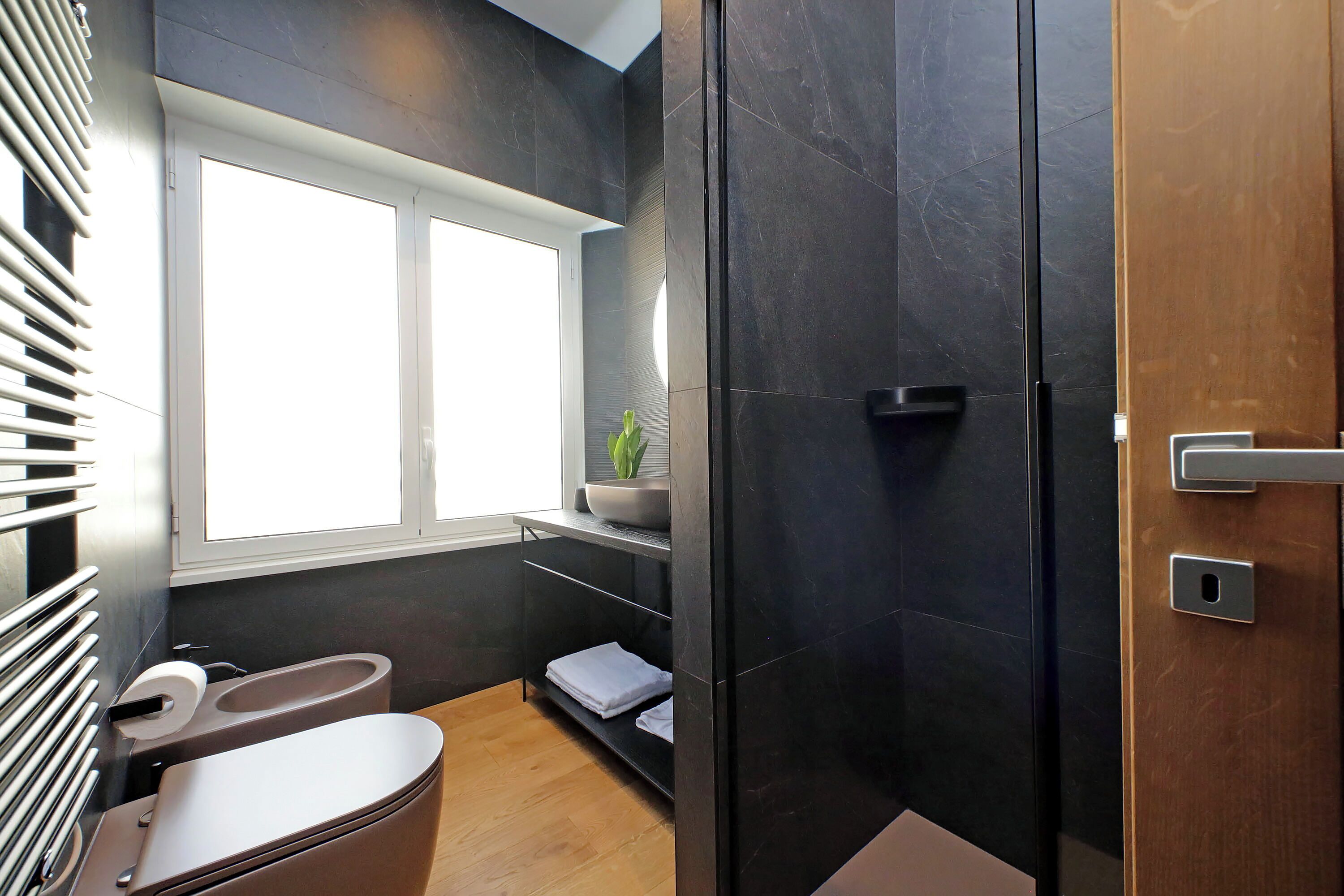 A modern bathroom with a toilet, sink, and shower area.
