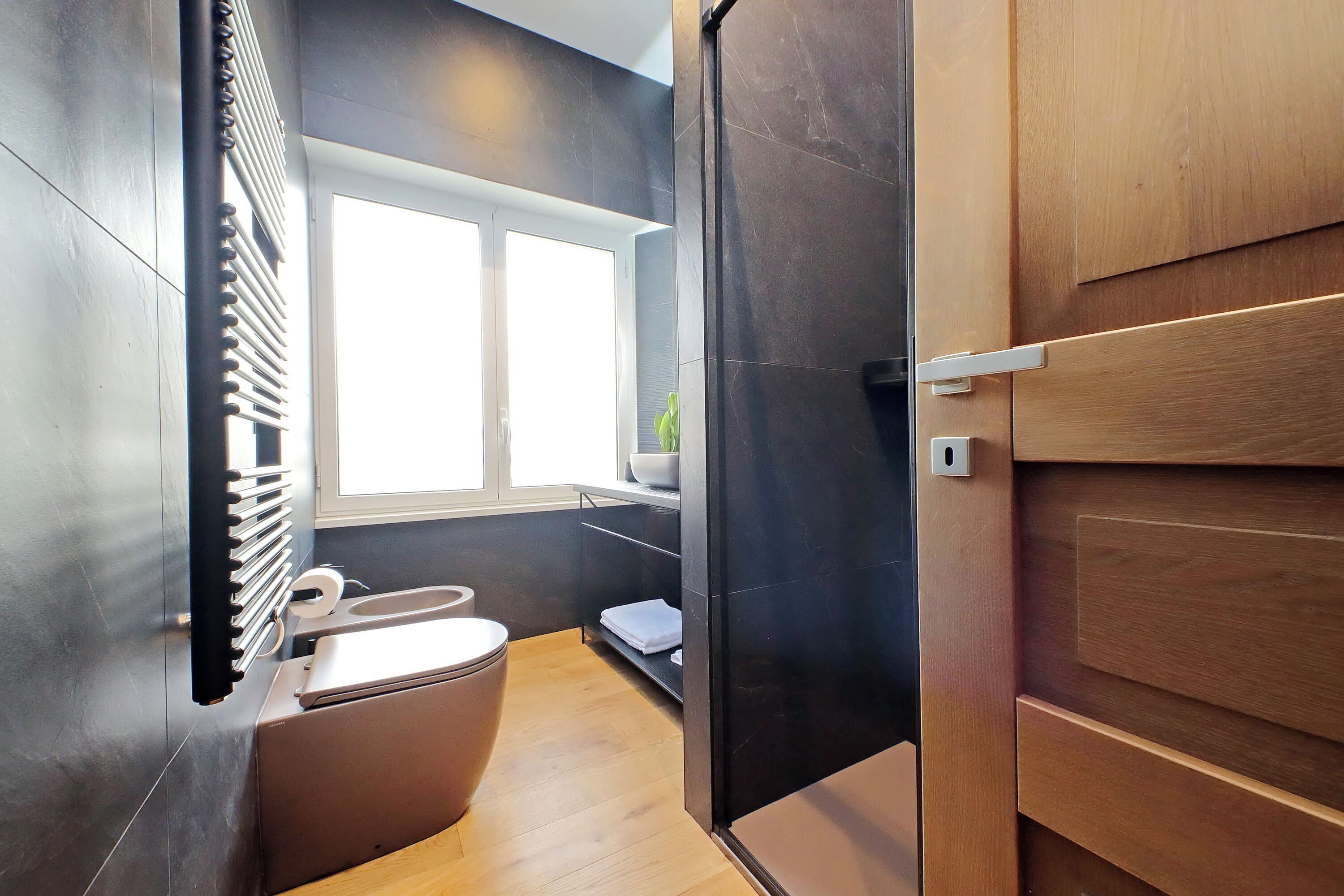A modern bathroom with a toilet, sink, and shower area.