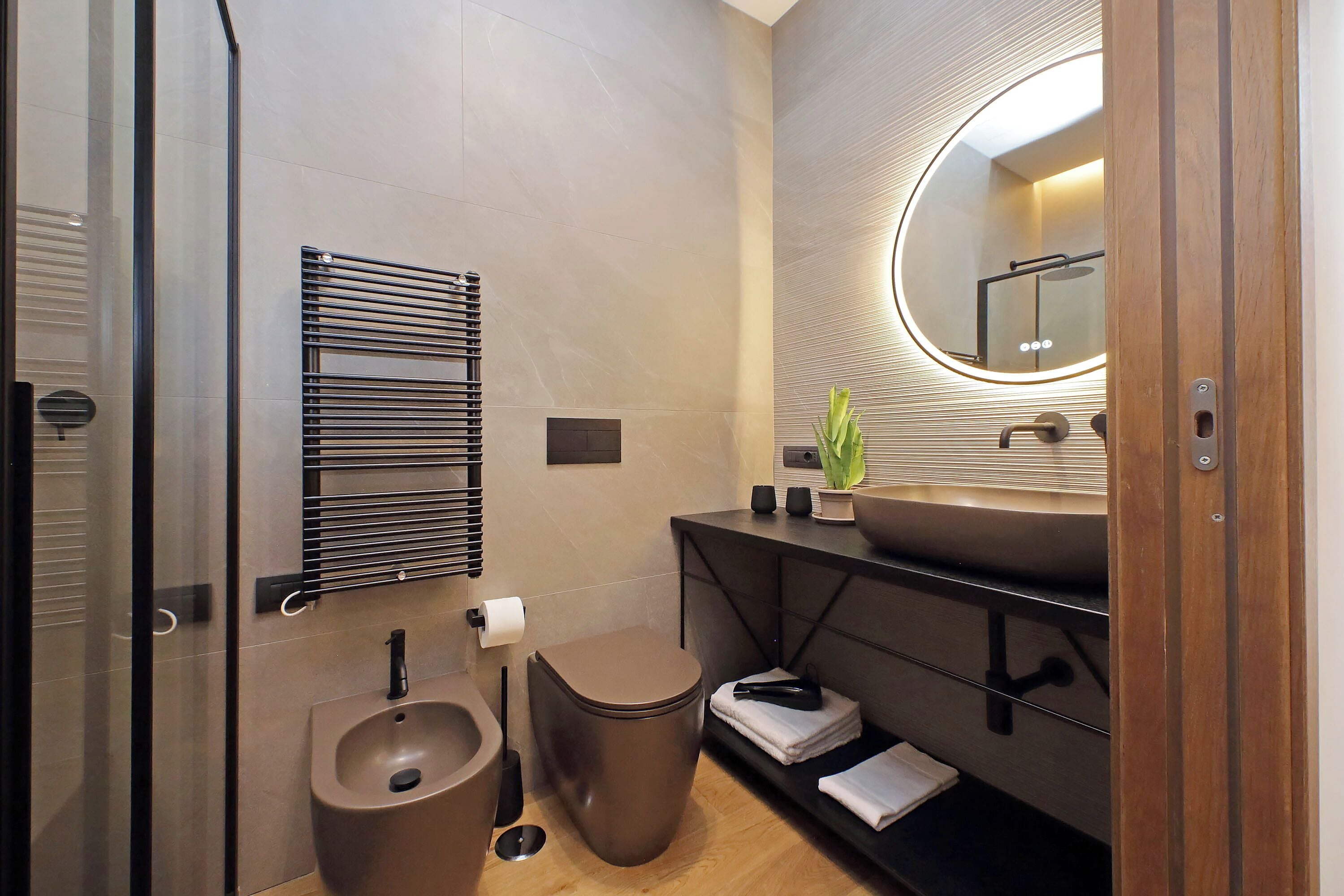 A modern bathroom with a toilet, bidet, and sink.