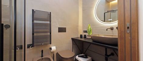 A modern bathroom with a toilet, bidet, and sink.