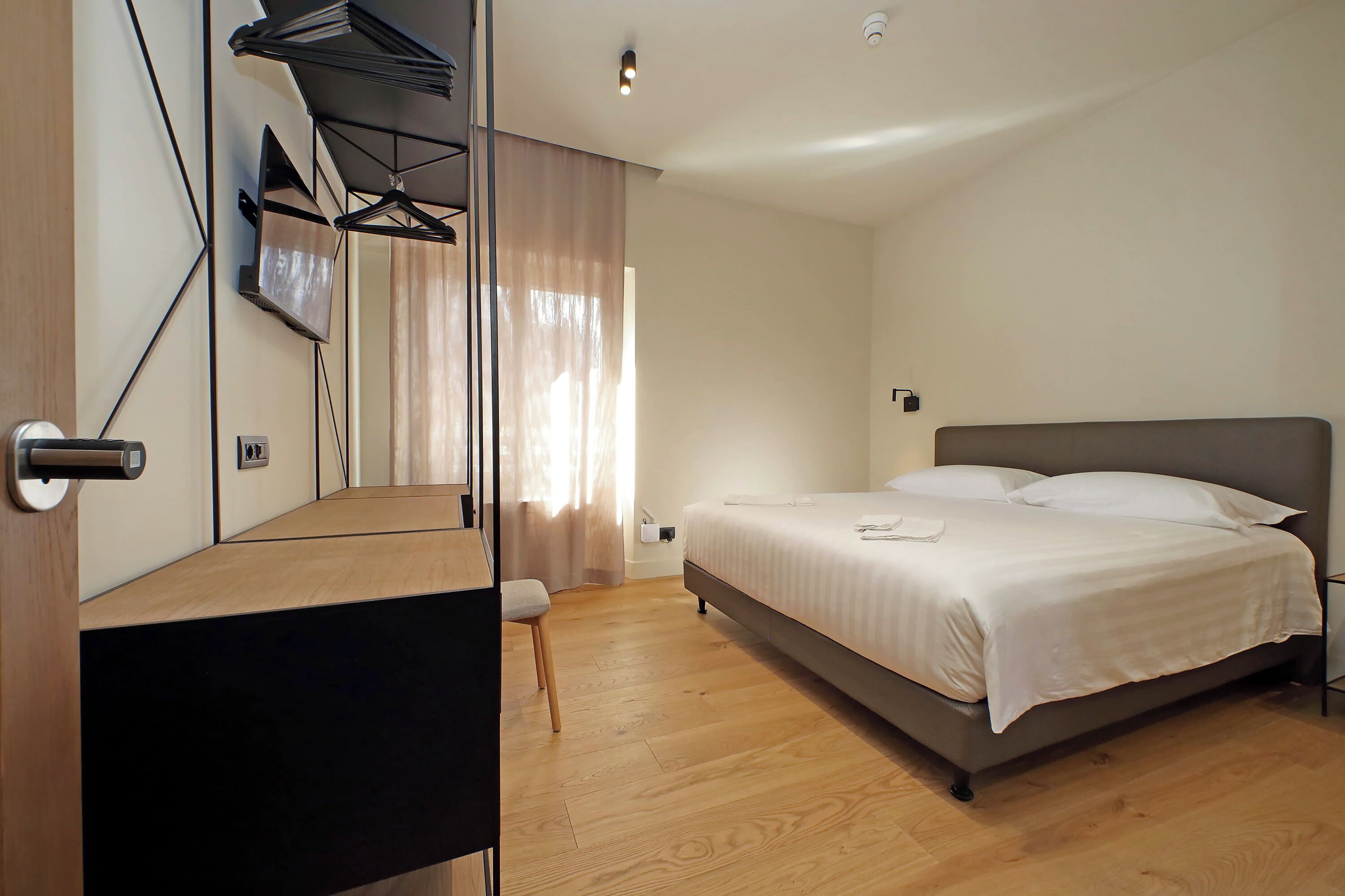A modern bedroom with a bed, a chair, and a wardrobe.