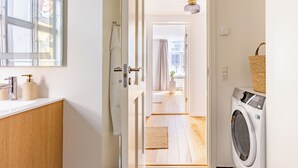 A laundry room with a washing machine, a hanging rack, and a basket on the wall. - Regent 15 - Bright 1 Bdr Apt right in the Centre of Copenhagen (København)