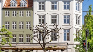 A row of multi-story buildings with distinct architectural styles, including a building with a green facade and a white building with a dormer window. - Regent 15 - Bright 1 Bdr Apt right in the Centre of Copenhagen (København)