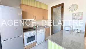 Una cocina moderna con electrodomésticos de acero inoxidable, armarios de madera y un salpicadero a rayas verdes.