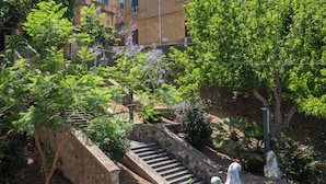 Un patio con una escalera, una estatua de cisne y edificios al fondo.
