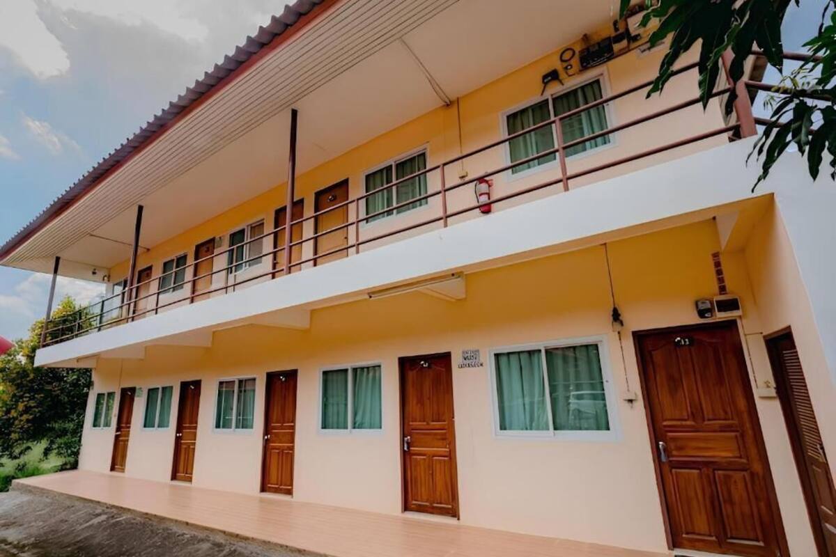 A two-story building with a flat roof, multiple windows, and a balcony.