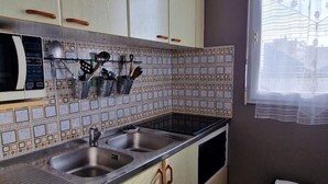 A kitchen with two sinks, a microwave, and a utensil holder.