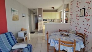 A compact living space with a dining area, kitchenette, and a view into the kitchen.