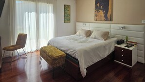 A bedroom with a bed, a chair, a nightstand, and a painting on the wall. - Prestigious villa Loire Valley (Saint-Avertin)