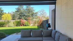 A covered patio with a grey sectional sofa and a wooden table. - Prestigious villa Loire Valley (Saint-Avertin)