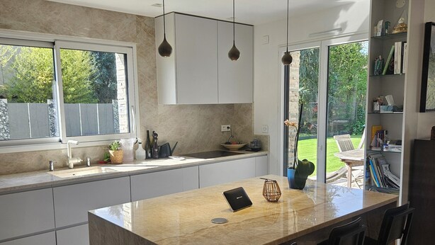 A modern kitchen with a large island, pendant lights, and a view of a garden. - Prestigious villa Loire Valley (Saint-Avertin)