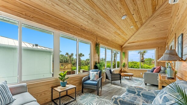A spacious room with large windows, wooden ceiling, and comfortable seating. - Shell Haven | Beach Villa | Pool + Spa (Melbourne Beach)