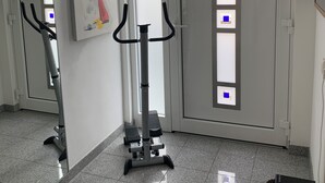 En gang med træningsmaskine, et billede og døre med satin glas.