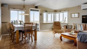 Un salón espacioso con suelo de madera, un comedor con mesa y sillas, y un sofá.