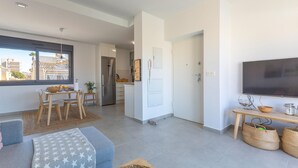 Un appartement moderne comprenant un coin repas, une cuisine et un espace de vie.