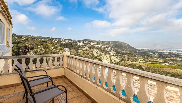 A balcony with two chairs, a view of a hilly landscape, and a clear sky. - Amazing home in Denia (Denia)