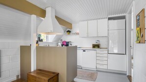 Ett modernt kök med vita skåp, en inbyggd ugn och en träbänk.