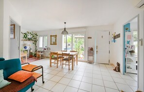 Relax in this inviting living area with a dining table, sofa, and refrigerator.