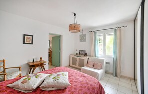 Cozy retreat with a large bed, wooden chair, and bedside table, perfect for a restful stay.