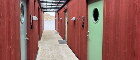 A corridor with red wooden walls, a green door, and a skylight.