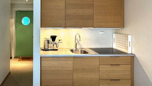 A compact kitchen with wooden cabinets, a stainless steel sink, and a coffee maker. - Pet friendly apartment in Søgne (Søgne)