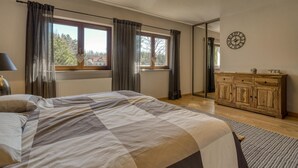A bedroom with a bed, a dresser, a clock, and a window with curtains. - Beautiful home in Olsztynek (Olsztynek)