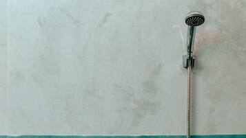 A bathroom with a shower, a toilet, and a bidet.