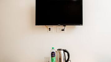 A television mounted on a wall with two power outlets below it.