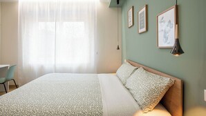A bedroom with a bed, a chair, a window with sheer curtains, and three framed pictures on the wall. - Aurelius Design Loft 2 by Cornelia Subway (Roma)
