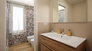 A bathroom with a wooden vanity, a white sink, and a toilet. - Aurelius Design Loft 2 by Cornelia Subway (Roma)