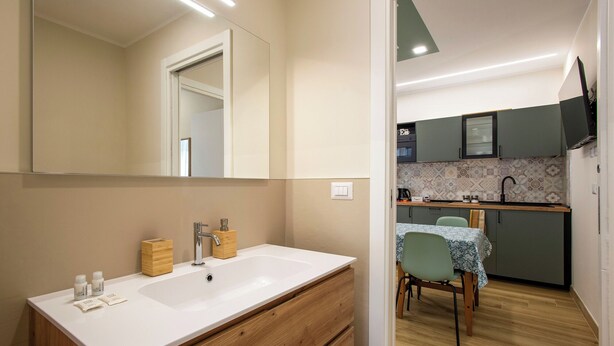 A modern bathroom with a large mirror, white sink, wooden cabinets, and a wooden vanity. - Aurelius Design Loft 2 by Cornelia Subway (Roma)
