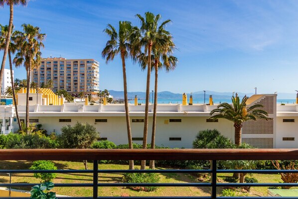 A hotel with multiple floors, palm trees, and a clear view of the mountains in the background. - Casa Álvaro - Sea views (Torremolinos)