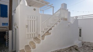 A white building with a stone staircase leading to a door. - Walkable distance from everything you need (Paros)