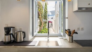 A modern kitchen with a built-in sink, a coffee maker, and a kettle. - Walkable distance from everything you need (Paros)