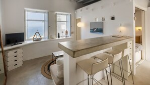 A modern kitchen with a large island, bar stools, and a dining area. - Walkable distance from everything you need (Paros)