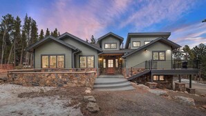 A two-story house with a stone foundation, a front porch, and a staircase leading to the second floor. - 34 Acre Escape~Games~Hiking~Pool Table~Bicycles (Black Hawk)