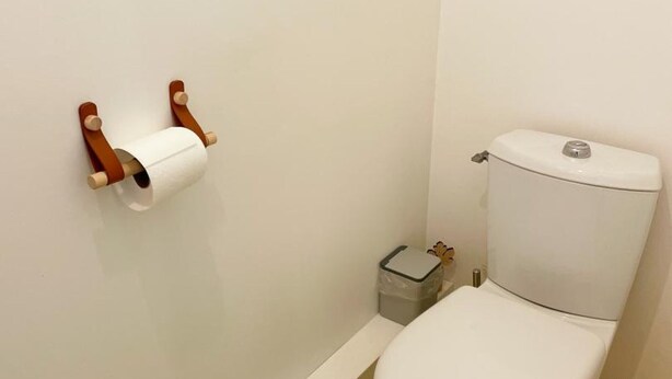 A small bathroom with a toilet, a toilet paper holder, and a trash bin. - Comfortable cottage, 2 bedrooms, garden, near Blois & Chambord (Saint-Claude-de-Diray)
